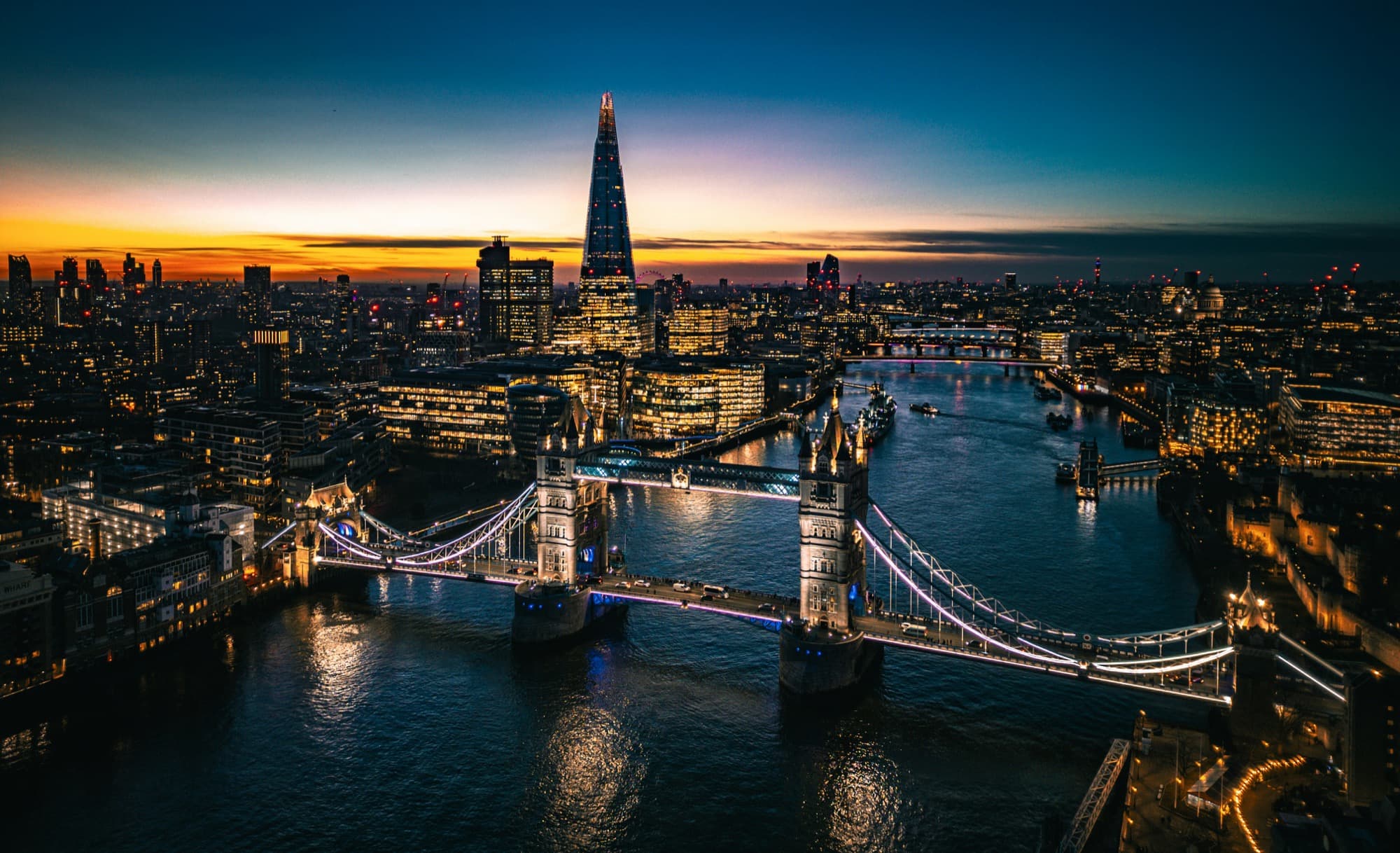 London from the air at dusk, Tower Bridge and the Shard lit